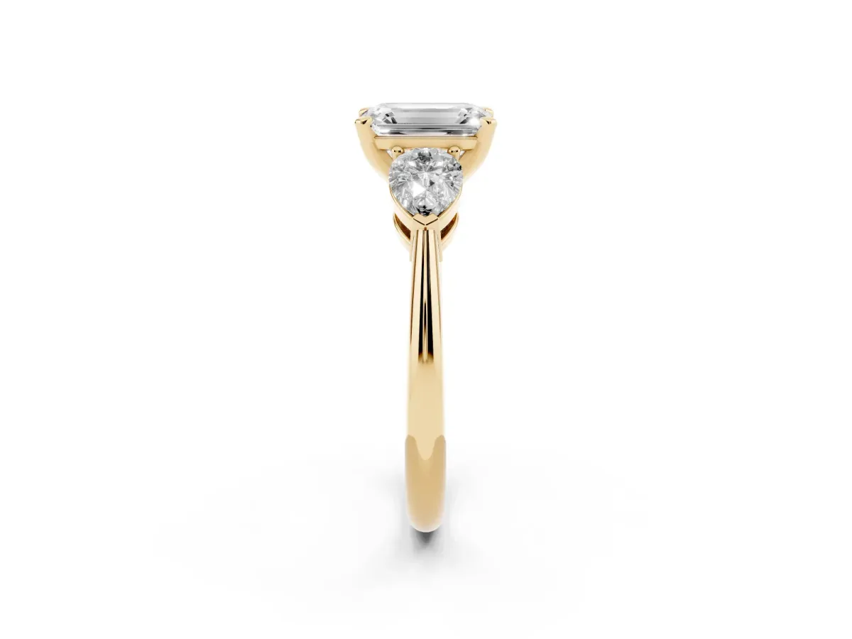 Three-Stone Emerald Cut Diamond Ring with Pear Side Stones and Four-Prong Setting Yellow gold