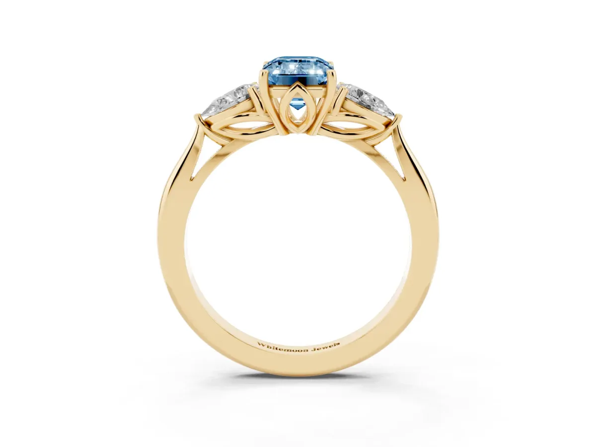 Fancy Blue Three-Stone Emerald Cut Diamond Ring with Pear Side Stones in Four-Prong Setting Yellow gold