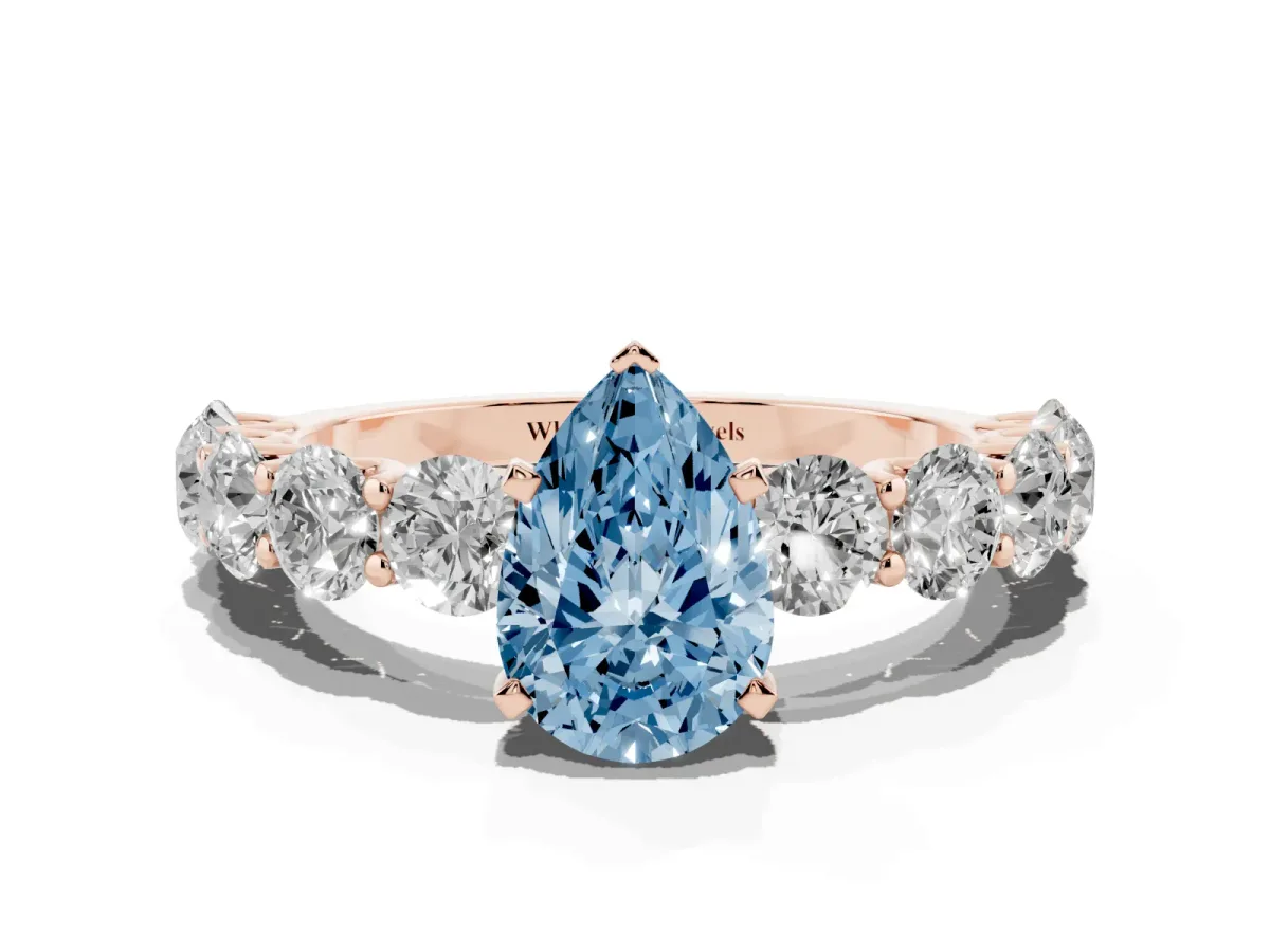 Fancy Blue Pear Cut Diamond Prong Setting with Side Stones on a Pave Band Rose gold