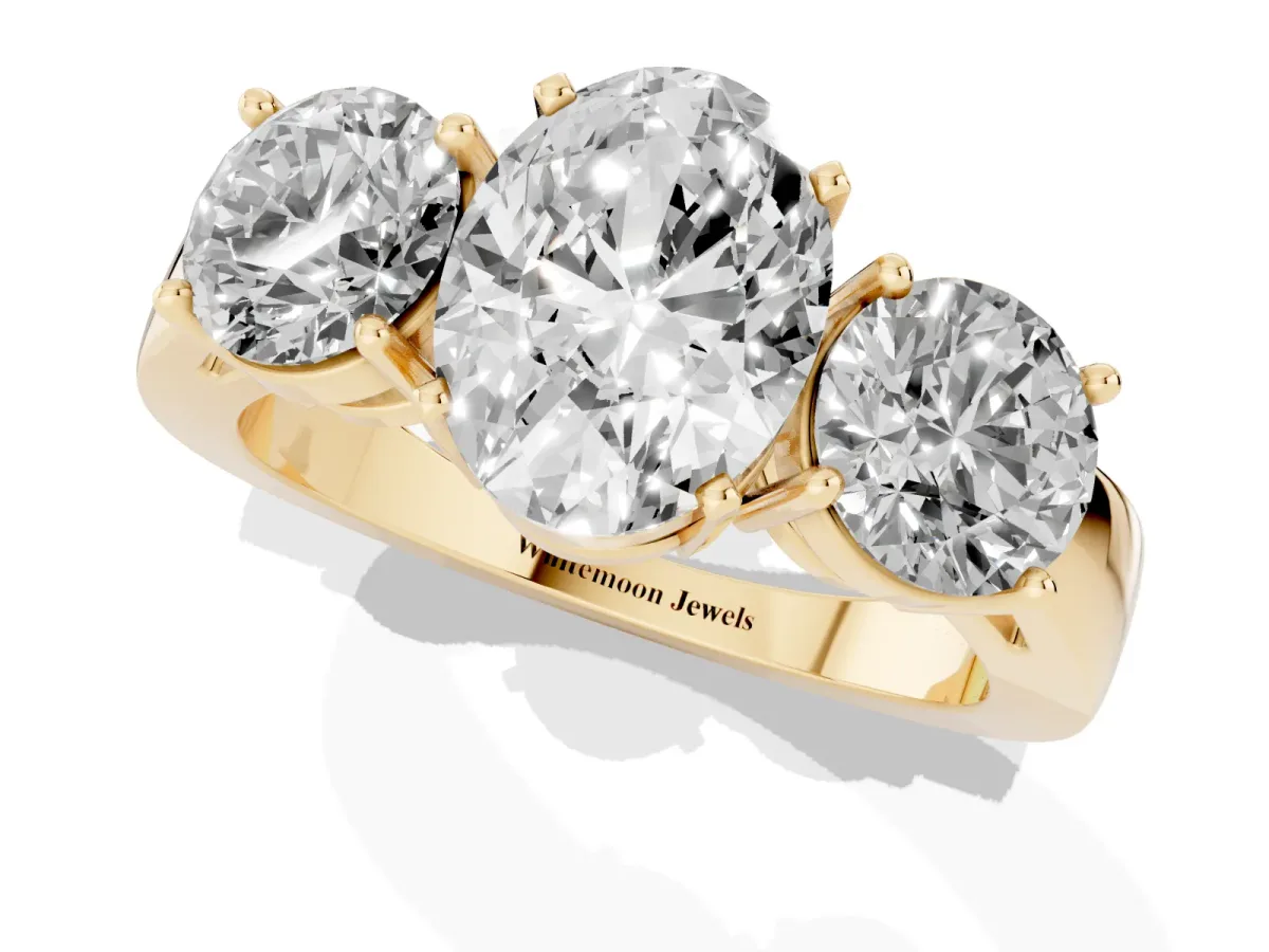 Three-Stone Oval Cut Diamond Ring with Round Side Stones, Classic Band, and Four-Prong Setting Yellow gold
