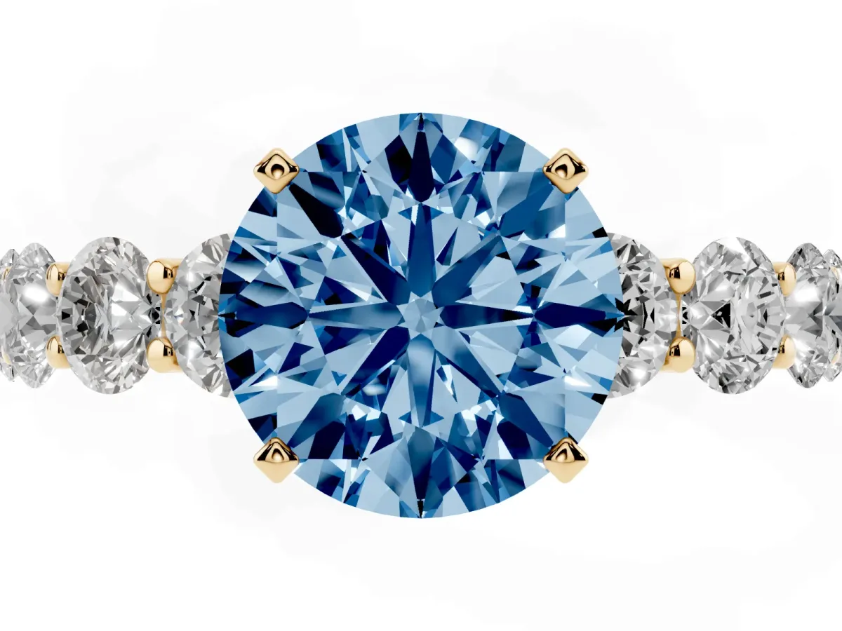Fancy Blue Round Cut Diamond Prong Setting with Side Stones on a Pave Band Yellow gold