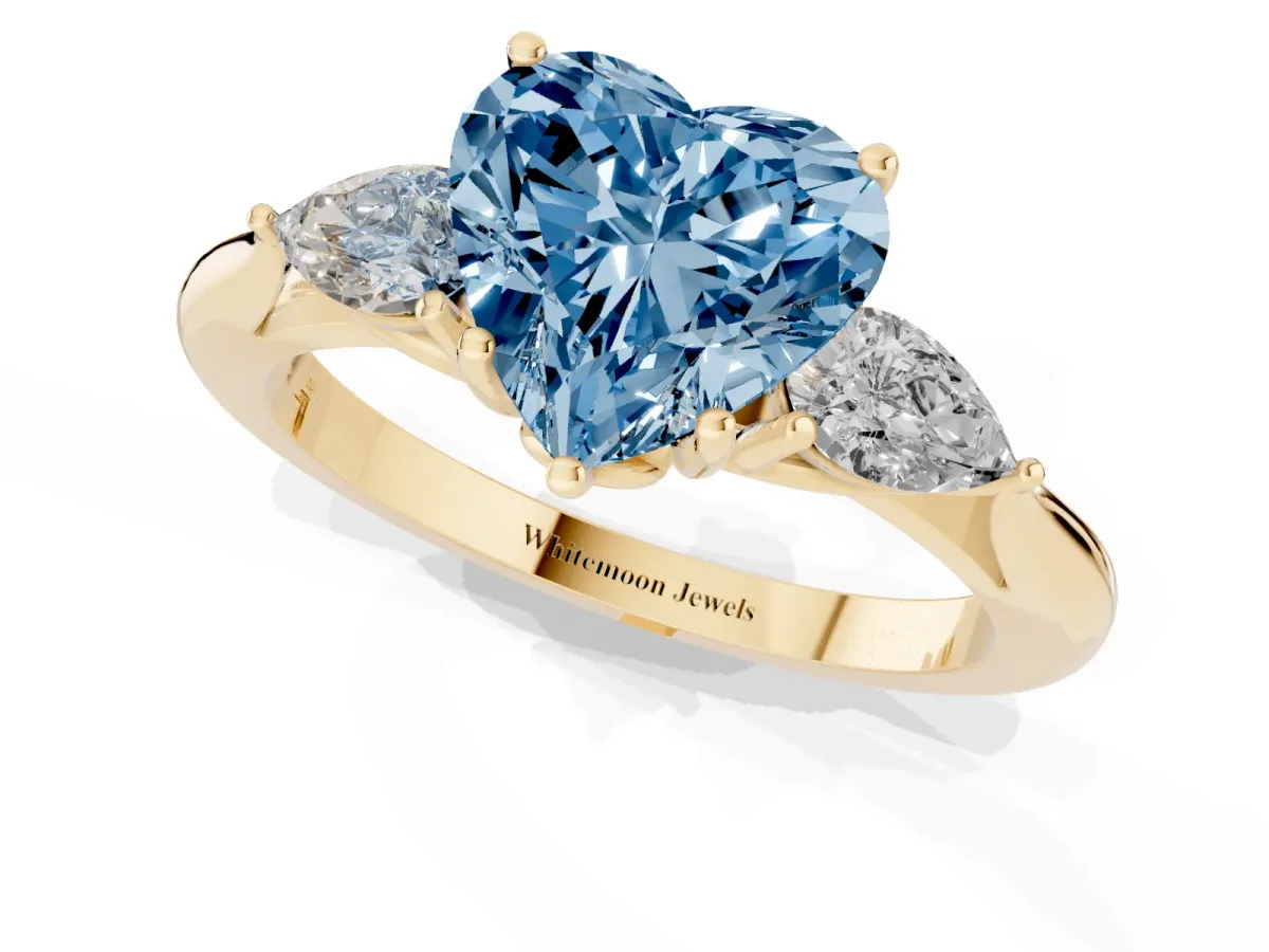 Fancy Blue Heart Cut Diamond Three-Stone Ring with Pear Side Stones and Prong Setting Yellow gold