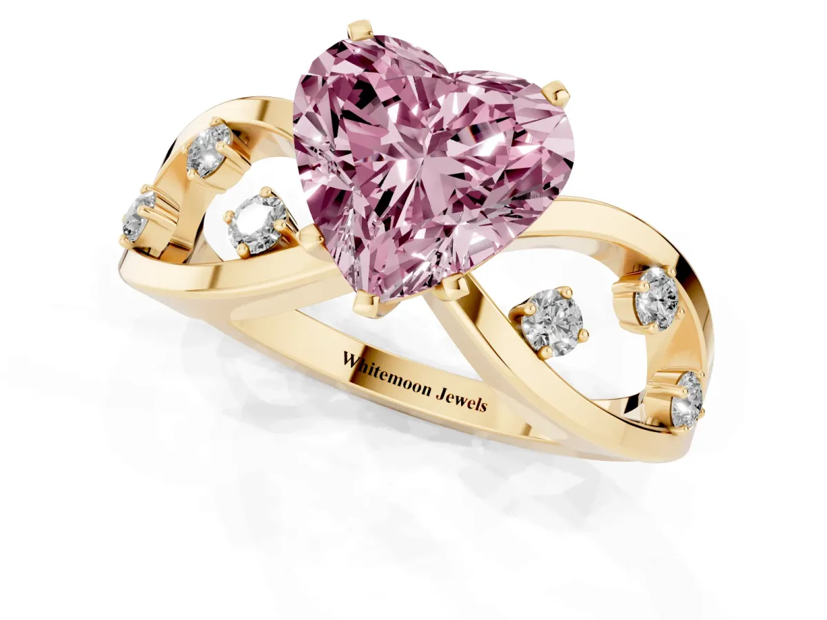 Fancy Pink Heart Cut Cut Solitaire Diamond with Side Stones on Criss-Cross Band and Four-Prong Setting Yellow gold