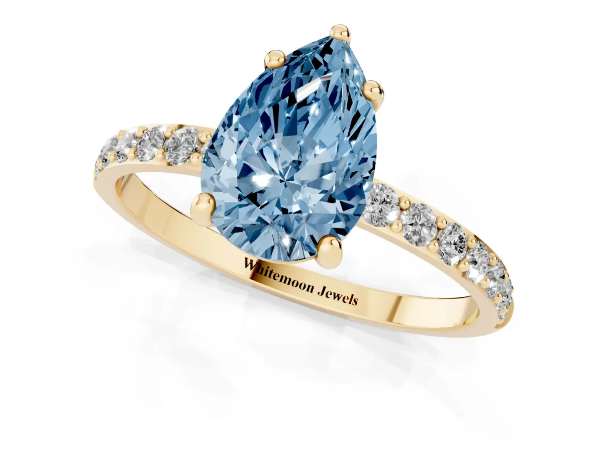 Fancy Blue Pear Cut Diamond Solitaire Ring with Round Pavé Band and Prong Setting Yellow gold
