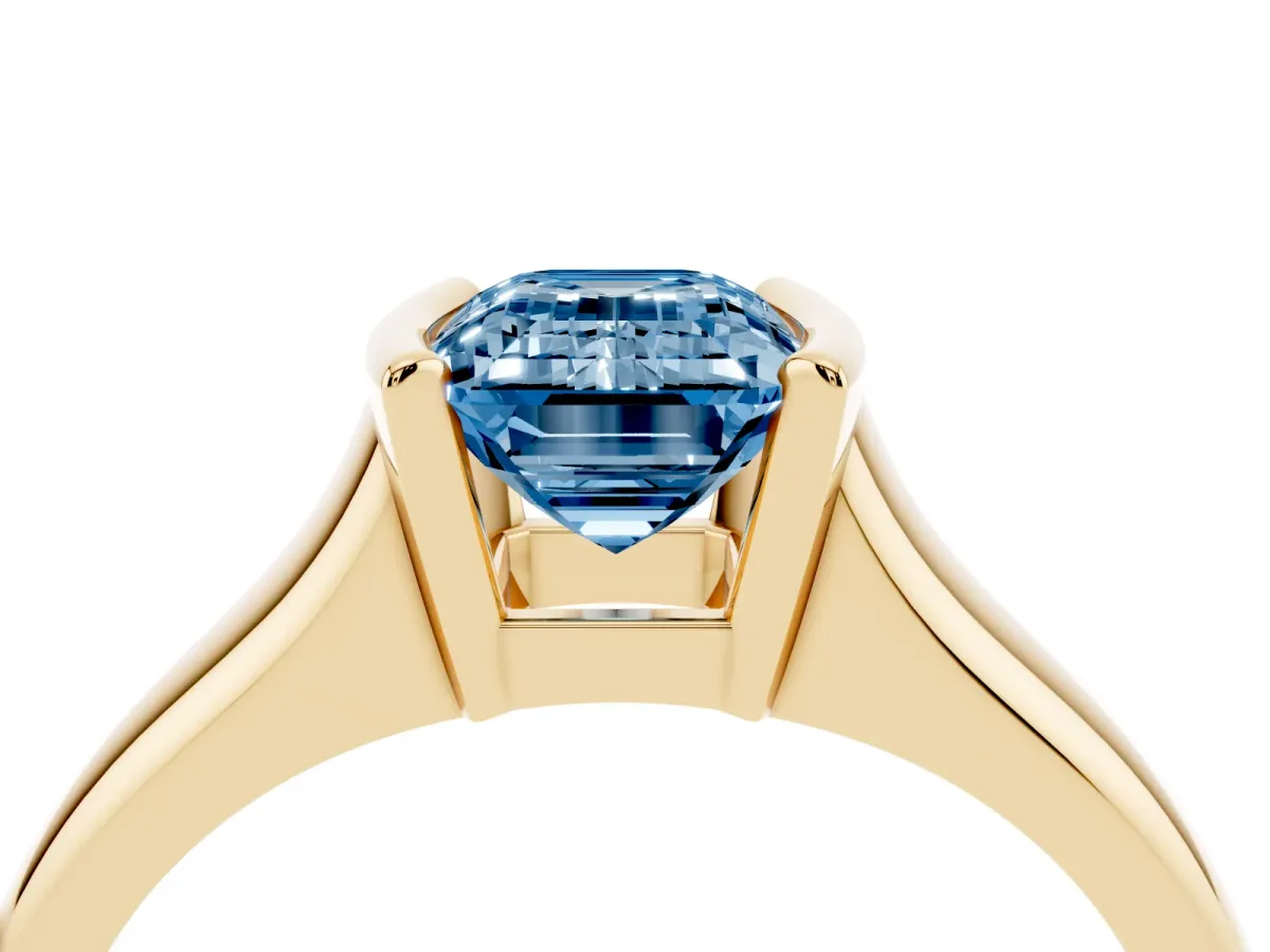 Fancy Blue Emerald Cut Solitaire Tension Set Diamond Ring with Split Shank Band Yellow gold