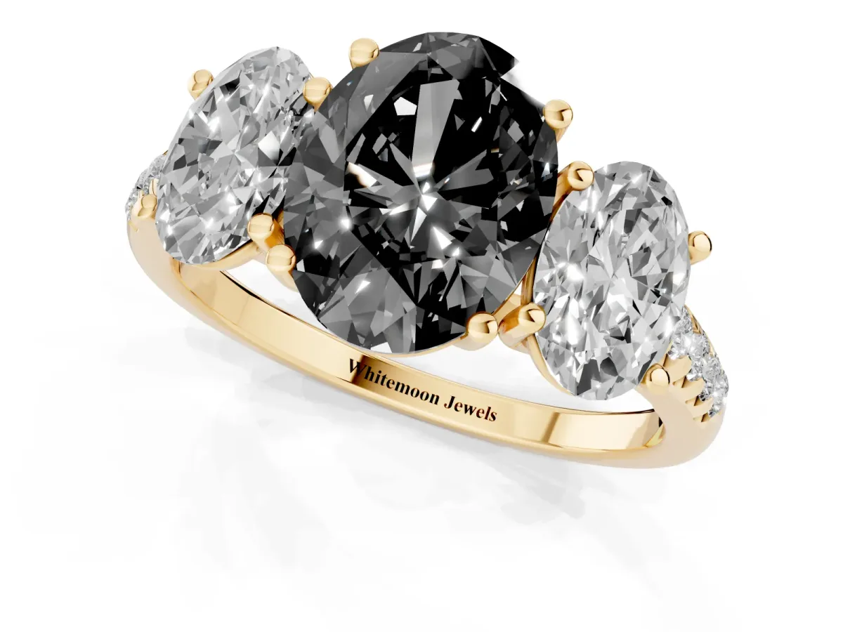 Fancy Black Three-Stone Oval Cut Diamond Ring with Round Pavé Band and Prong Setting Yellow gold