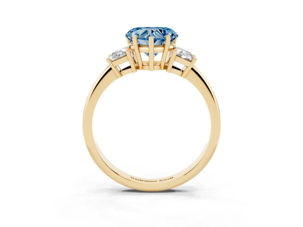 Fancy Blue Heart Cut Diamond Three-Stone Ring with Trapezoid Side Stones and Prong Setting Yellow gold