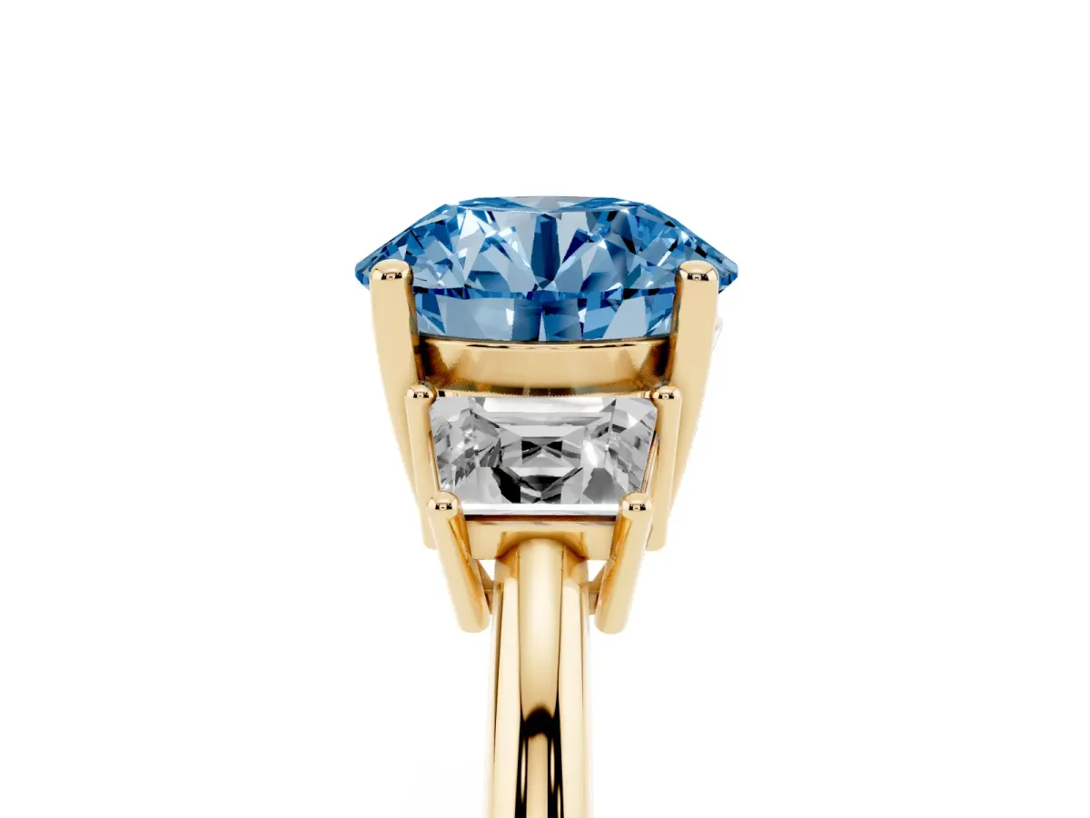 Fancy Blue Round Cut Diamond Three-Stone Ring with Trapezoid Side Stones and Prong Setting Yellow gold