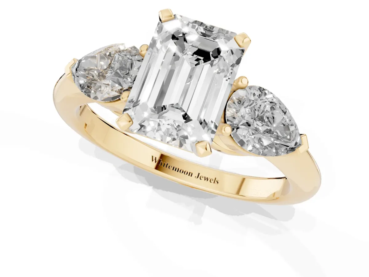 Three-Stone Emerald Cut Diamond Ring with Pear Side Stones and Four-Prong Setting Yellow gold
