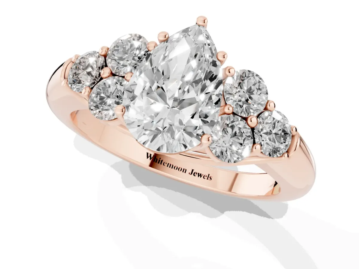 Pear Cut Cut Diamond Cluster Ring with Round Accent Stones and Prong Setting on a Classic Band Rose gold