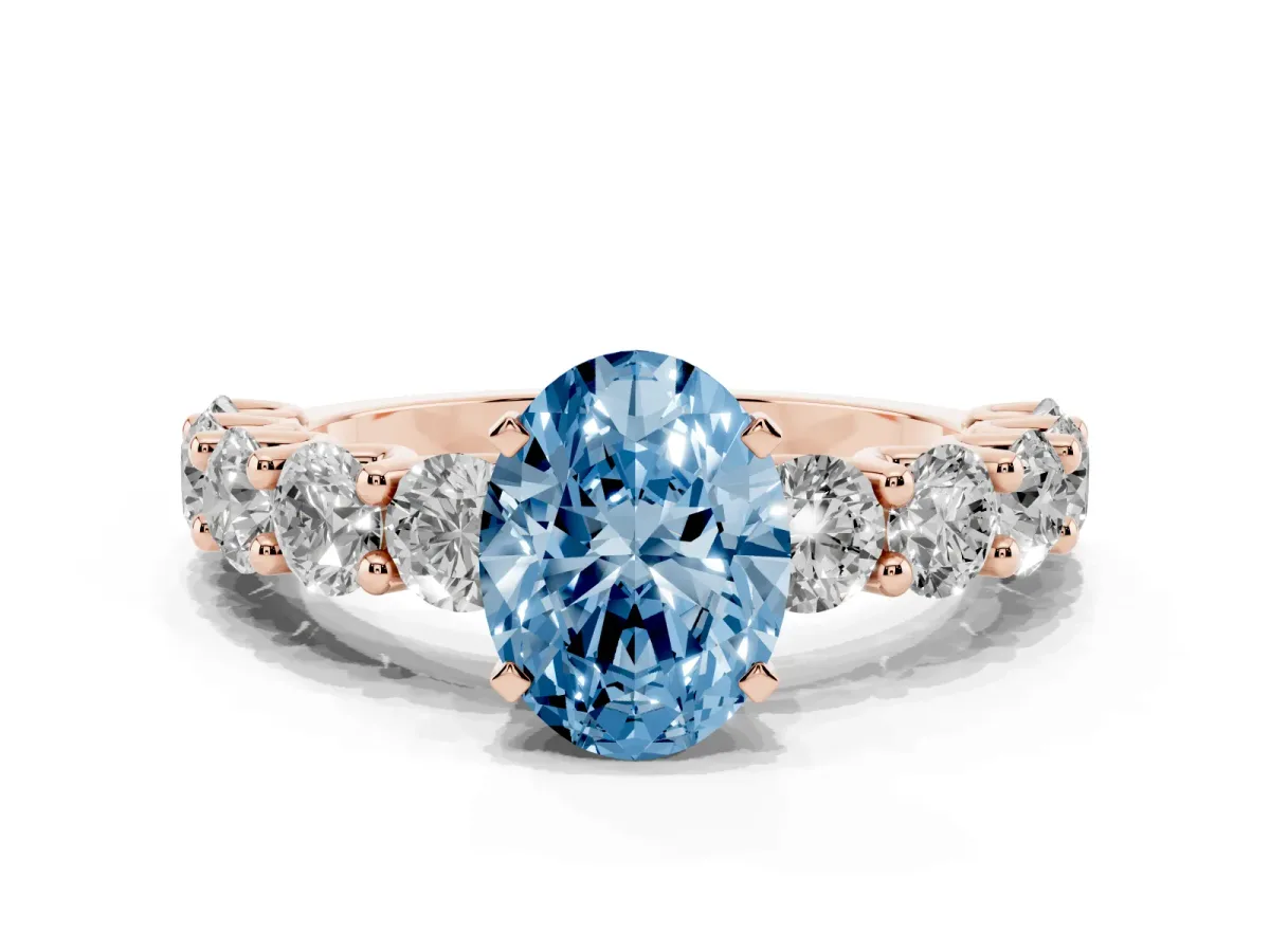 Fancy Blue Oval Cut Diamond Prong Setting with Side Stones on a Pave Band Rose gold