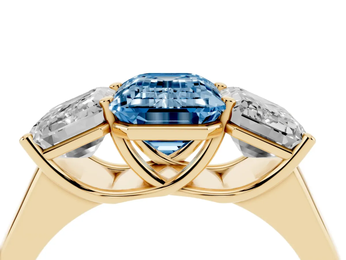 Fancy Blue Emerald Cut Three-Stone Diamond Ring with Prong Setting on a Classic Band Yellow gold