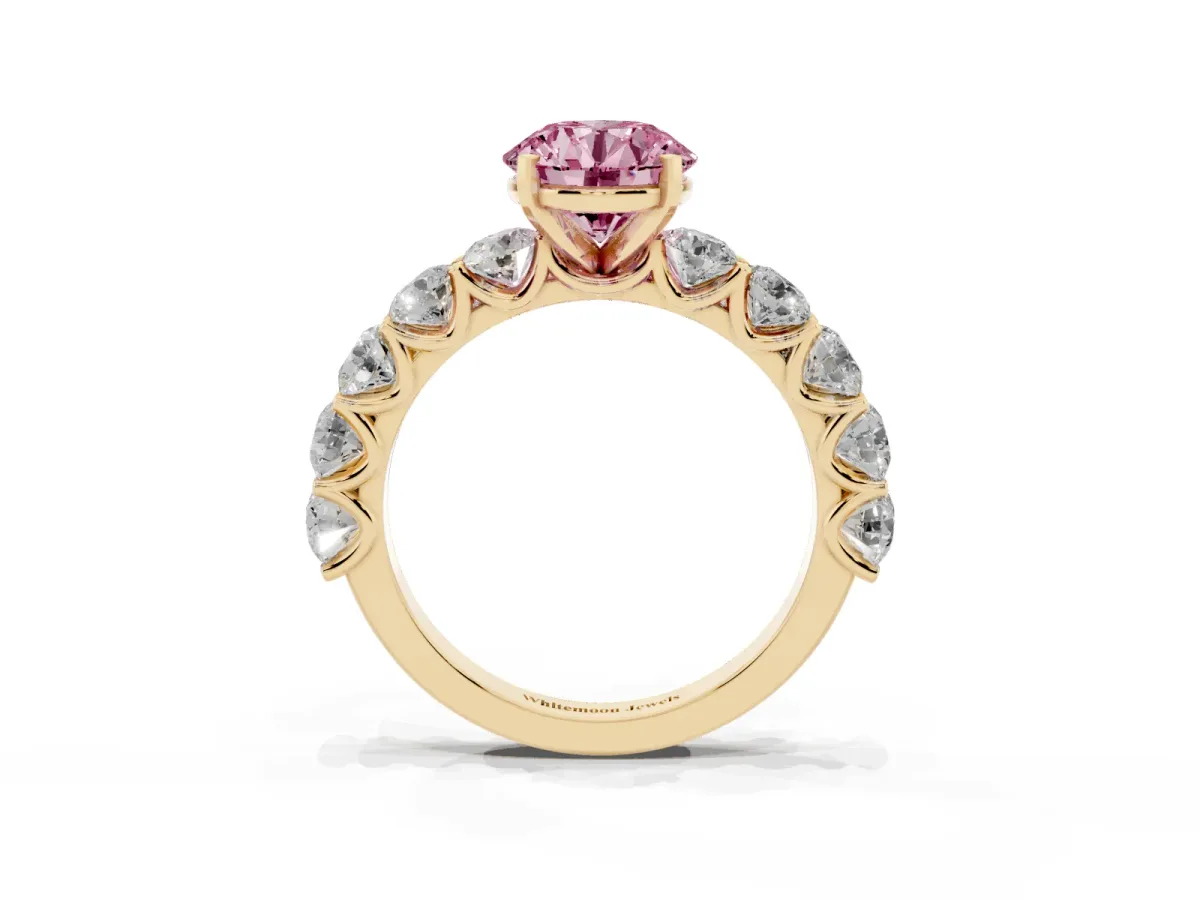 Fancy Pink Round Cut Diamond Prong Setting with Side Stones on a Pave Band Yellow gold