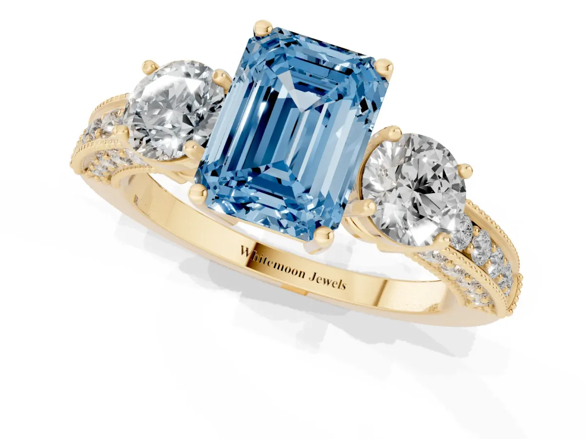 Fancy Blue Emerald Cut Three-Stone Diamond Ring with Pavé Band and Four-Prong Setting Yellow gold