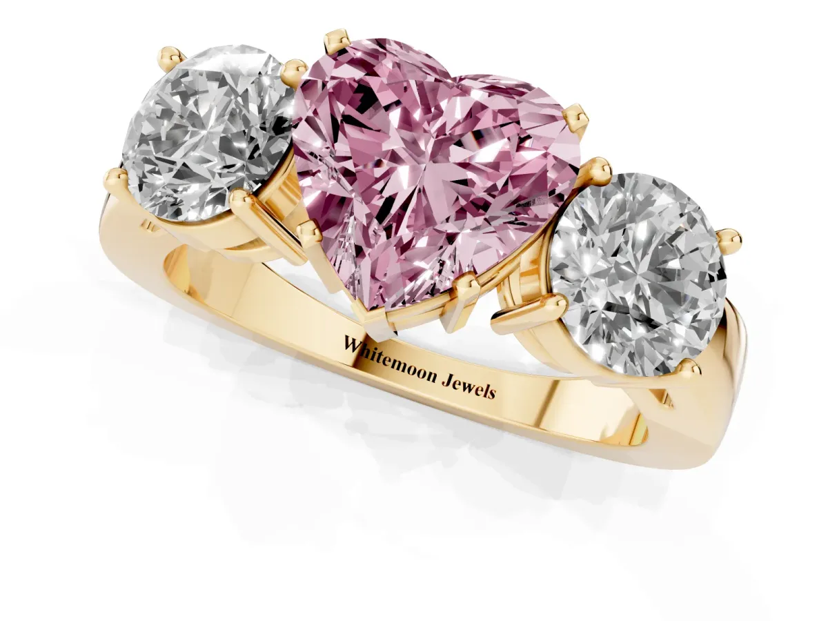 Fancy Pink Three-Stone Heart Cut Diamond Ring with Round Side Stones, Classic Band, and Four-Prong Setting Yellow gold