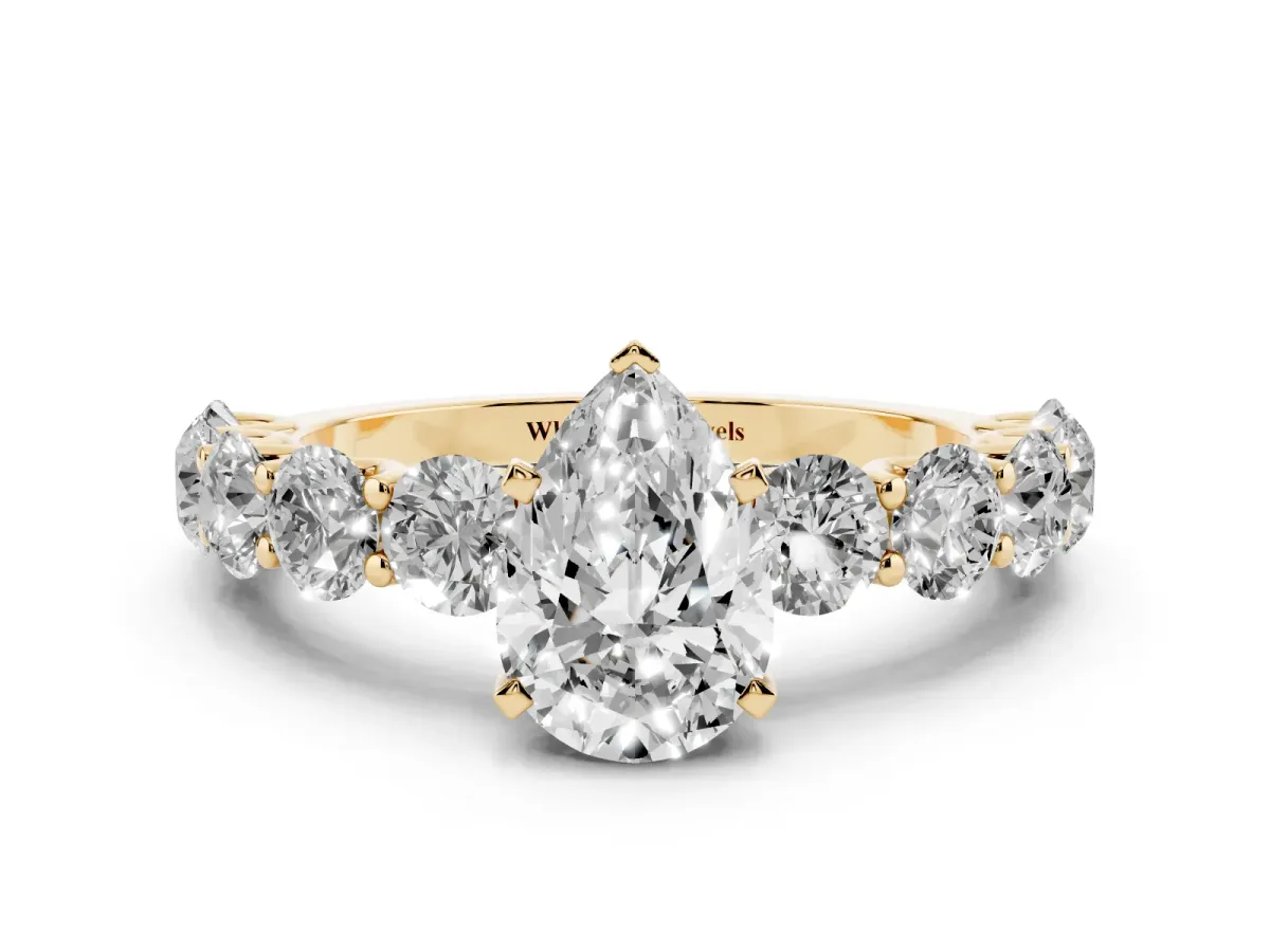 Pear Cut Diamond Prong Setting with Side Stones on a Pave Band Yellow gold