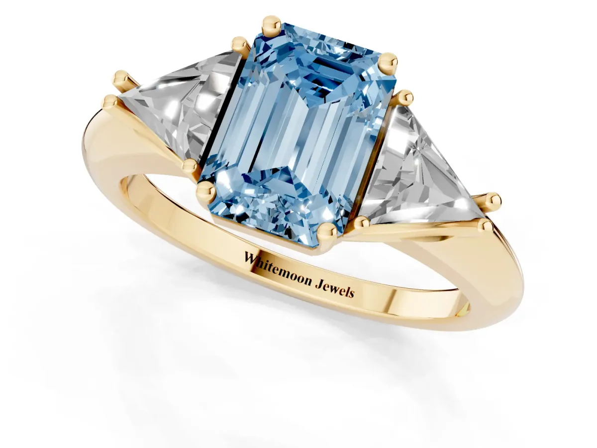 Fancy Blue Three-Stone Emerald Cut Diamond Engagement Ring with Trillion Side Stones and Prong Setting Yellow gold