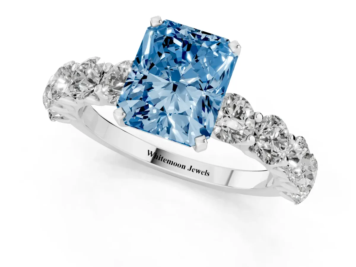 Fancy Blue Radiant Cut Diamond Prong Setting with Side Stones on a Pave Band Platinum