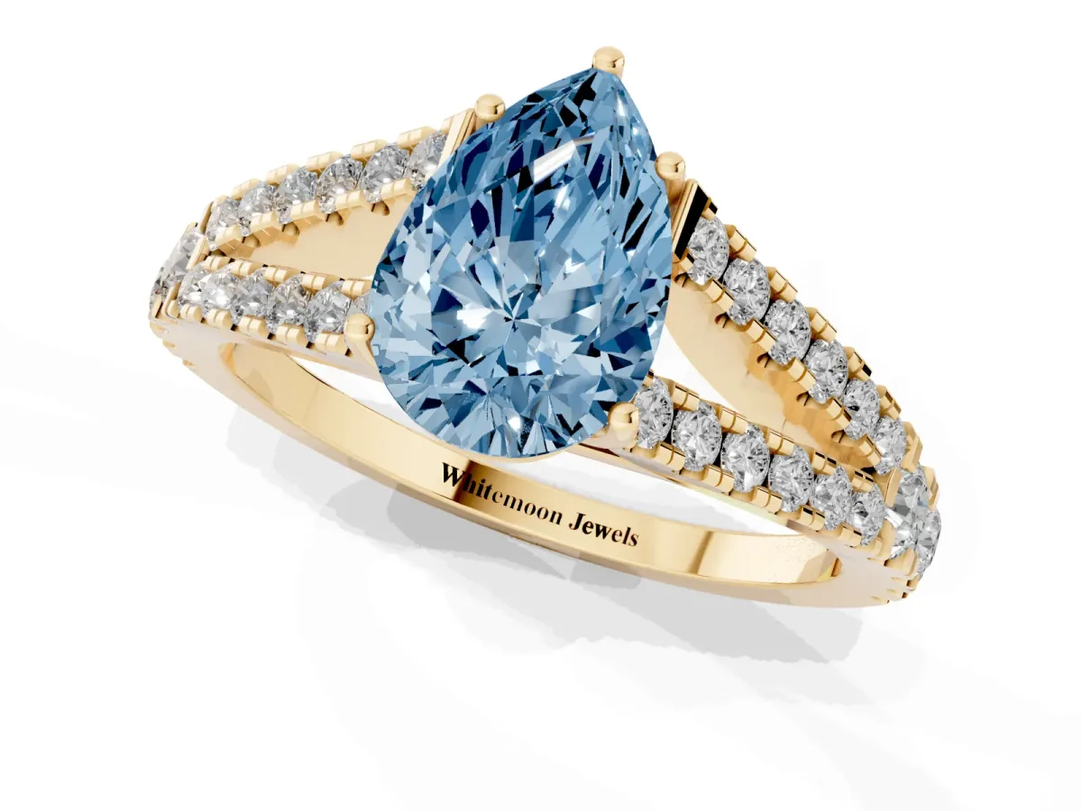 Fancy Blue Pear Cut Diamond Split Shank Engagement Ring with Round Pavé and Prong Setting Yellow gold