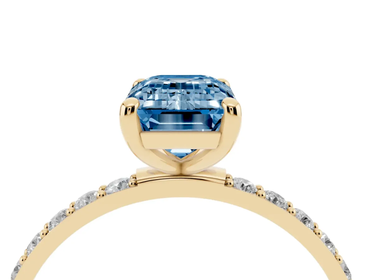 Fancy Blue Emerald Cut Diamond Solitaire Ring with Round Pavé Band and Prong Setting Yellow gold