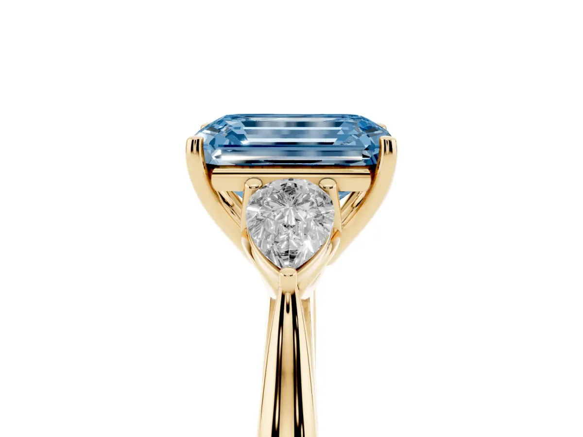 Fancy Blue Three-Stone Emerald Cut Brilliant Diamond Solitaire Ring with Tapered Band and Four-Prong Setting Yellow gold