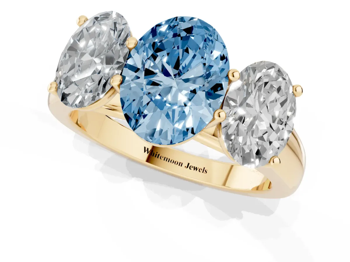 Fancy Blue Oval Cut Three-Stone Diamond Ring with Prong Setting on a Classic Band Yellow gold