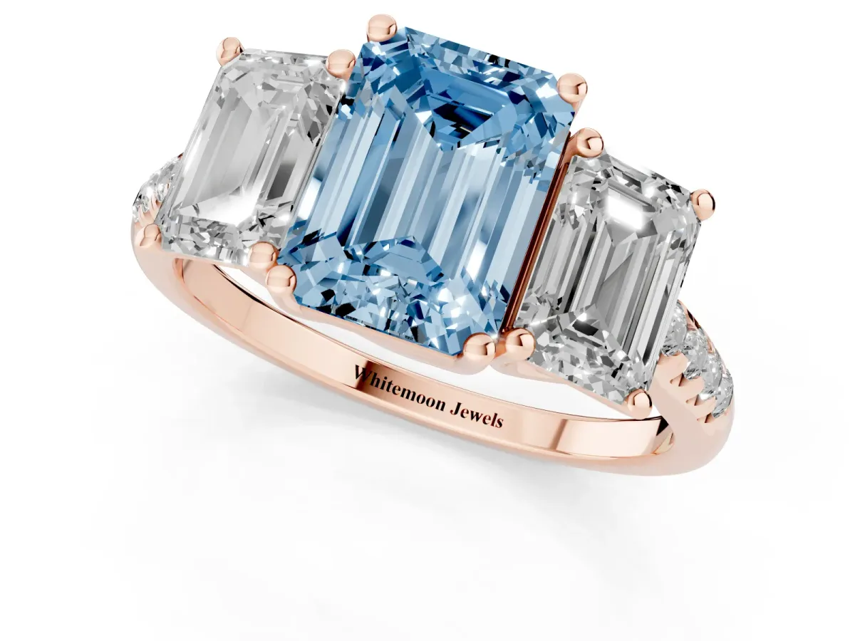 Fancy Blue Three-Stone Emerald Cut Diamond Ring with Round Pavé Band and Prong Setting Rose gold