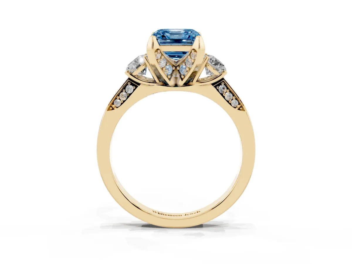 Fancy Blue Asscher Cut Brilliant Three-Stone Diamond Ring with Pavé Band and Four-Prong Setting Yellow gold