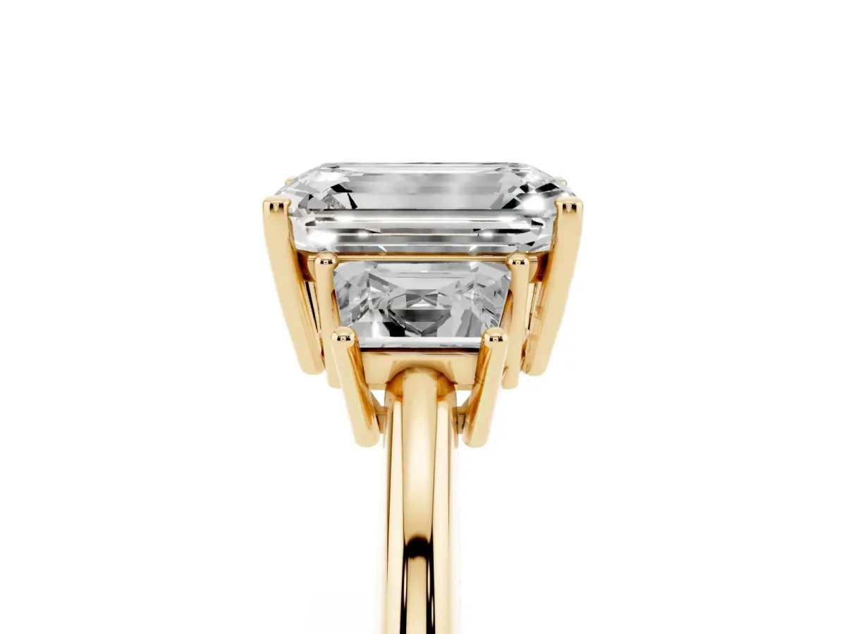 Emerald Cut Diamond Three-Stone Ring with Trapezoid Side Stones and Prong Setting Yellow gold