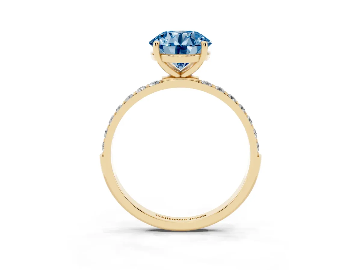 Fancy Blue Round Cut Diamond Solitaire Ring with Round Pavé Shoulders and Prong Setting Yellow gold