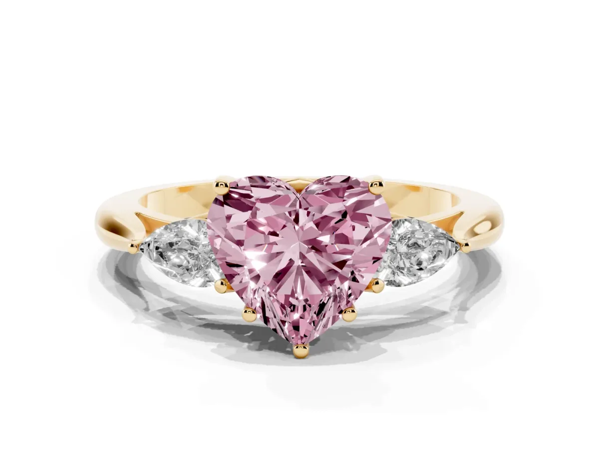 Fancy Pink Three-Stone Heart Cut Brilliant Diamond Solitaire Ring with Tapered Band and Four-Prong Setting Yellow gold