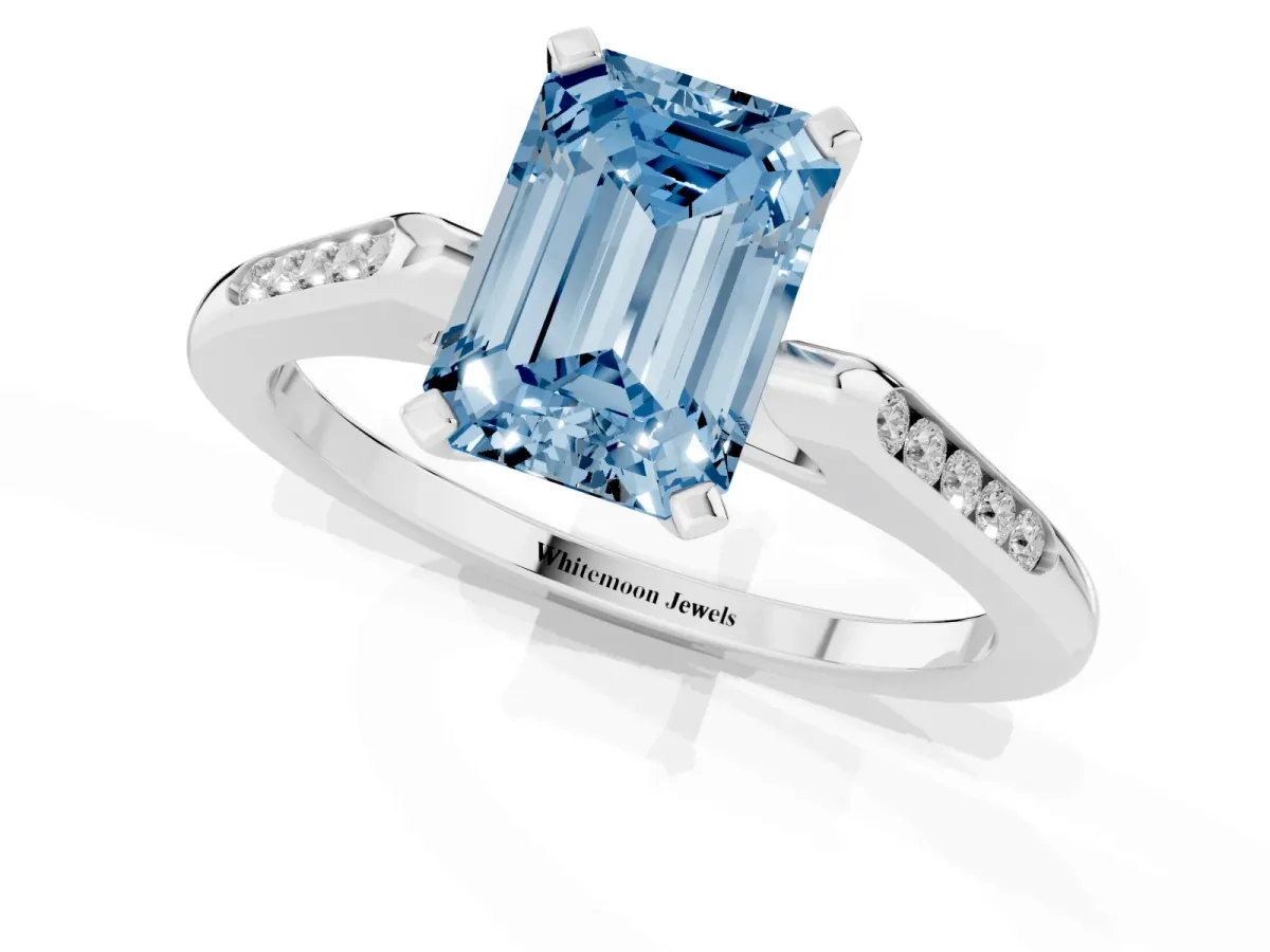 Fancy Blue Emerald Cut Diamond Solitaire Ring with Channel Set Round Band and Prong Setting Silver