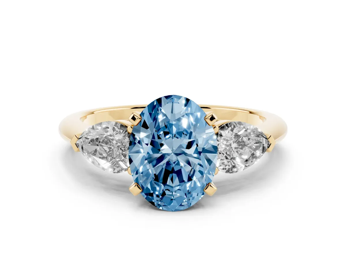 Fancy Blue Three-Stone Oval Cut Diamond Ring with Pear Side Stones and Four-Prong Setting Yellow gold