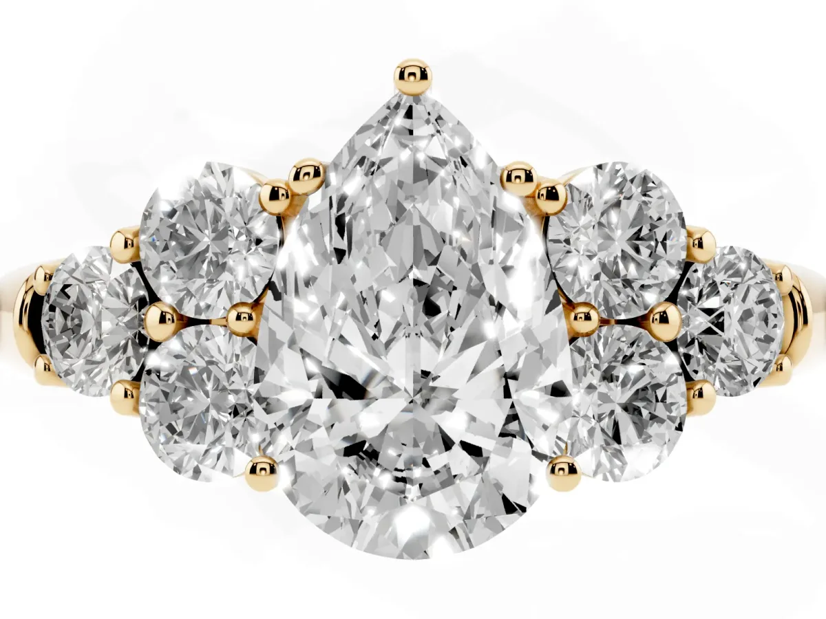Pear Cut Cut Diamond Cluster Ring with Round Accent Stones and Prong Setting on a Classic Band Yellow gold