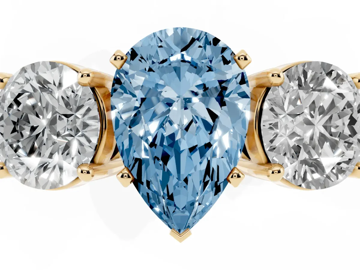 Fancy Blue Three-Stone Pear Cut Diamond Ring with Round Side Stones, Classic Band, and Four-Prong Setting Yellow gold