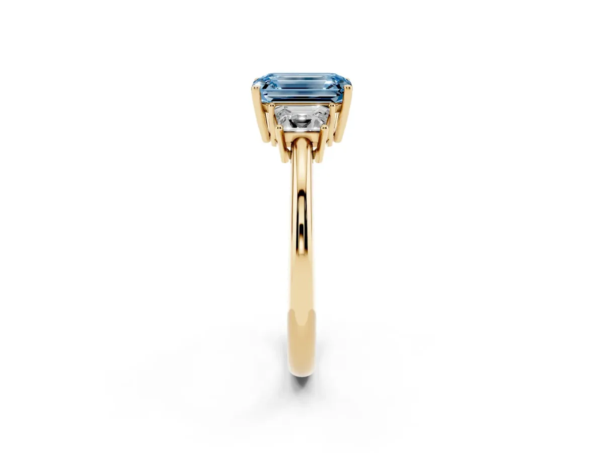 Fancy Blue Emerald Cut Diamond Three-Stone Ring with Trapezoid Side Stones and Prong Setting Yellow gold
