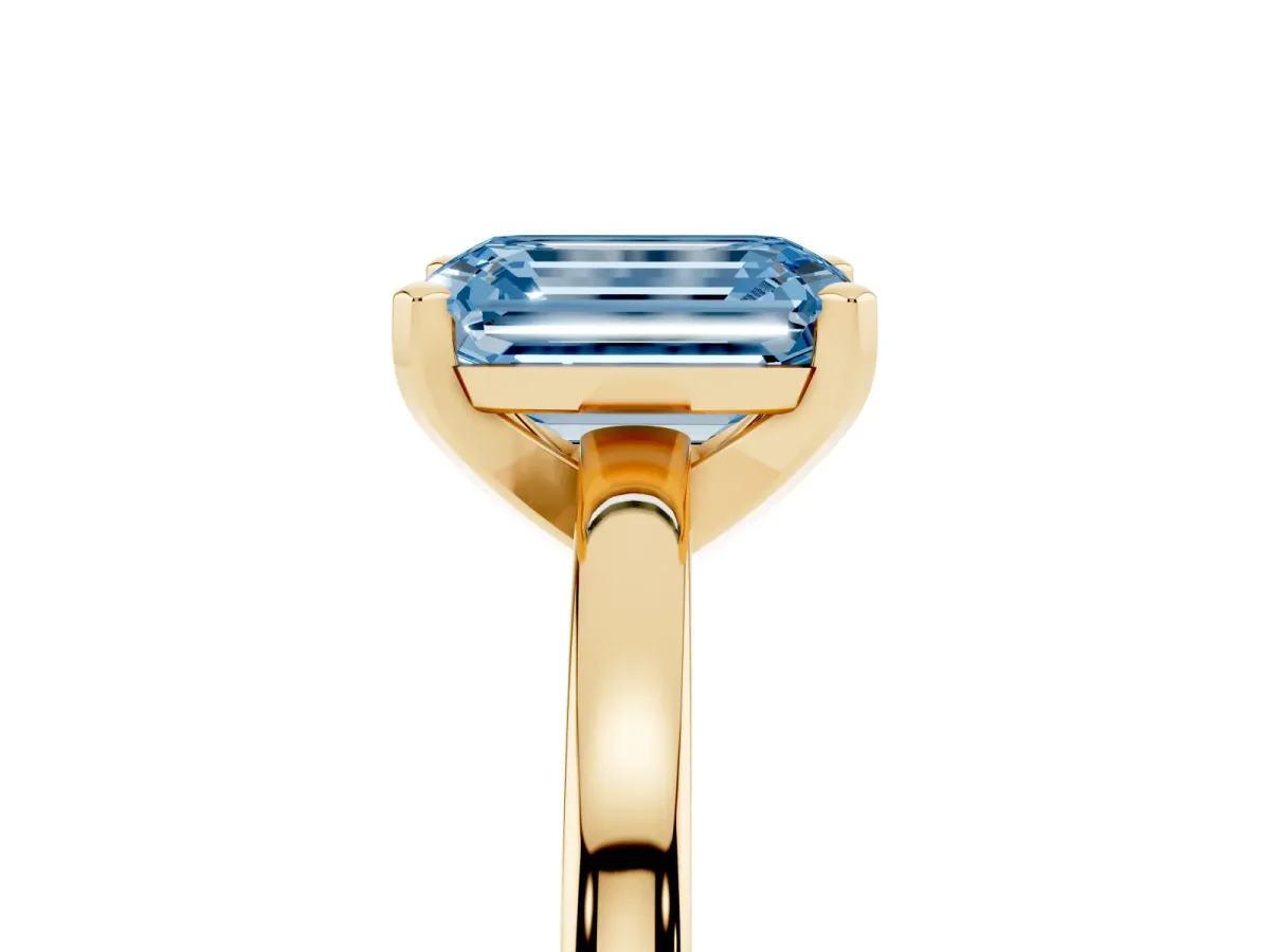 Fancy Blue Emerald Cut Solitaire Diamond Engagement Ring with Four-Prong Setting on a Classic Band Yellow gold