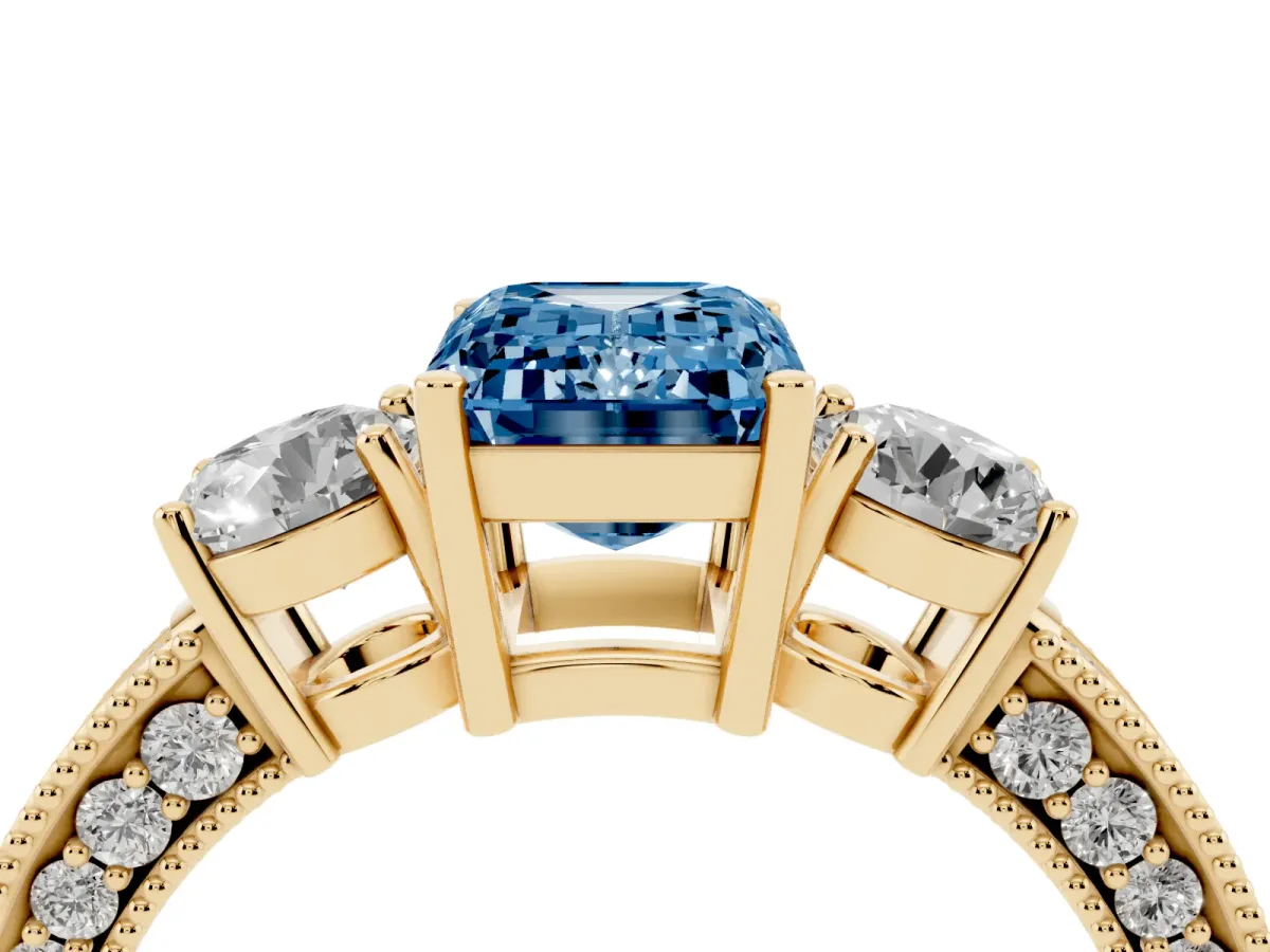 Fancy Blue Emerald Cut Three-Stone Diamond Ring with Pavé Band and Four-Prong Setting Yellow gold