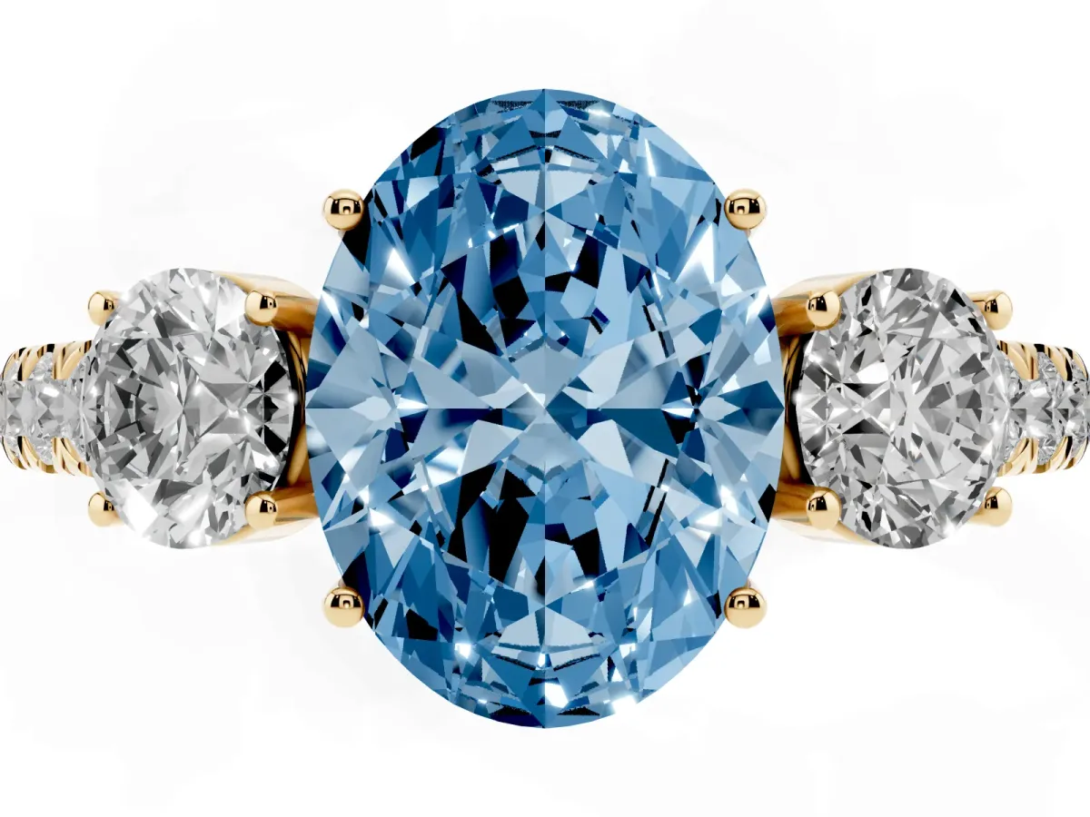 Fancy Blue Oval Cut Cut Diamond Three-Stone Ring with Round Side Stones and Pavé Band Yellow gold