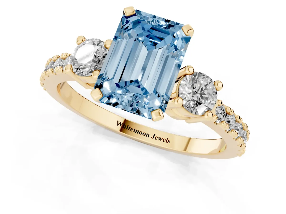 Fancy Blue Emerald Cut Three-Stone Diamond Pavé Band with Prong Setting Yellow gold