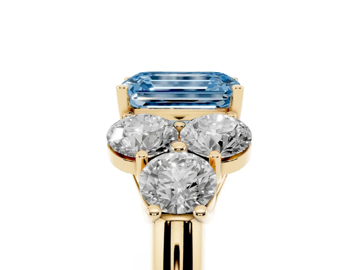 Fancy Blue Emerald Cut Cut Diamond Cluster Ring with Round Accent Stones and Prong Setting on a Classic Band Yellow gold