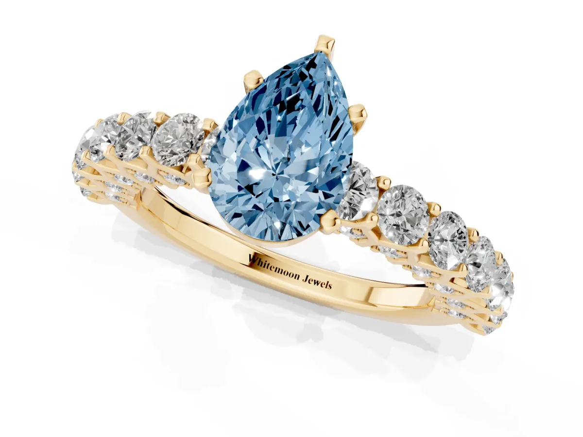 Fancy Blue Pear Cut Diamond Solitaire Ring with Shared Prong Pavé Band and Four-Prong Setting Yellow gold