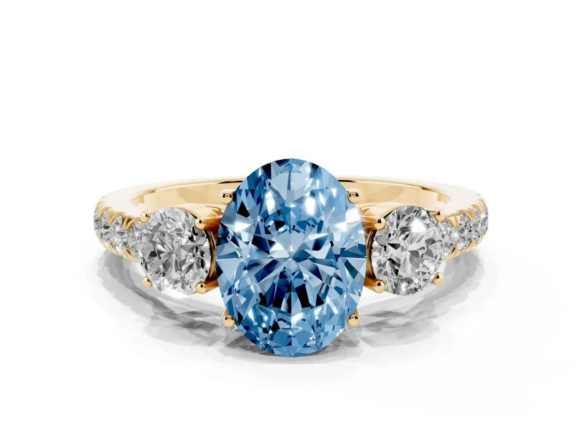 Fancy Blue Oval Cut Cut Diamond Three-Stone Ring with Round Side Stones and Pavé Band Yellow gold