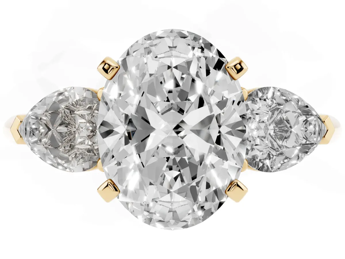 Three-Stone Oval Cut Diamond Ring with Pear Side Stones and Four-Prong Setting Yellow gold