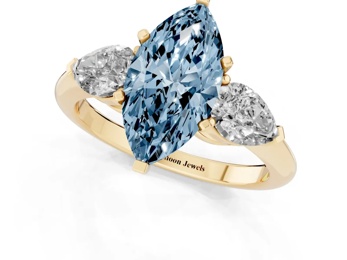 Fancy Blue Three-Stone Marquise Cut Diamond Ring with Pear Side Stones and Four-Prong Setting Yellow gold