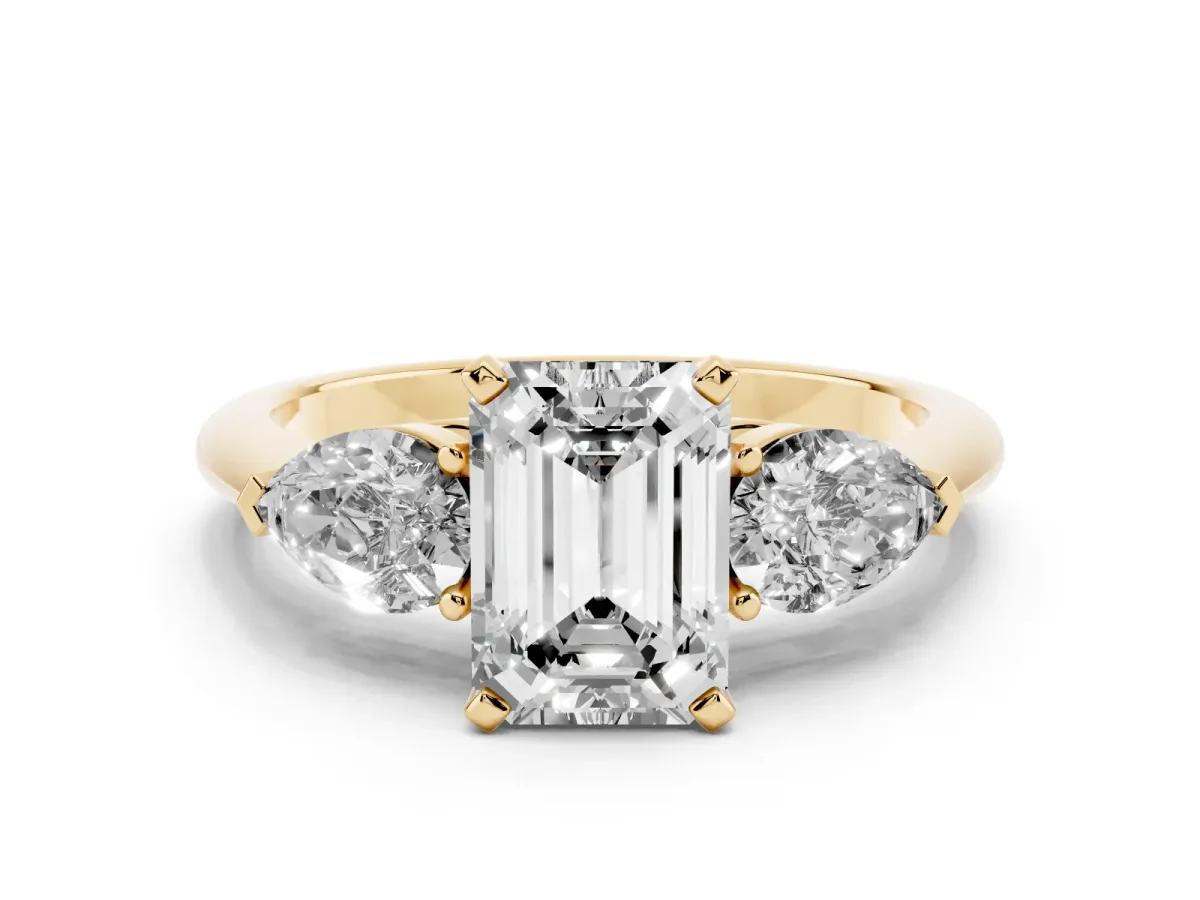Three-Stone Emerald Cut Diamond Ring with Pear Side Stones and Four-Prong Setting Yellow gold
