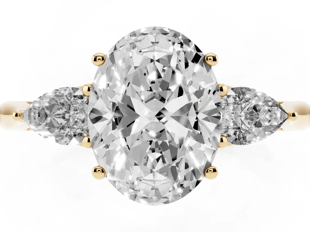 Three-Stone Oval Cut Diamond Ring with Pear Side Stones in Four-Prong Setting Yellow gold