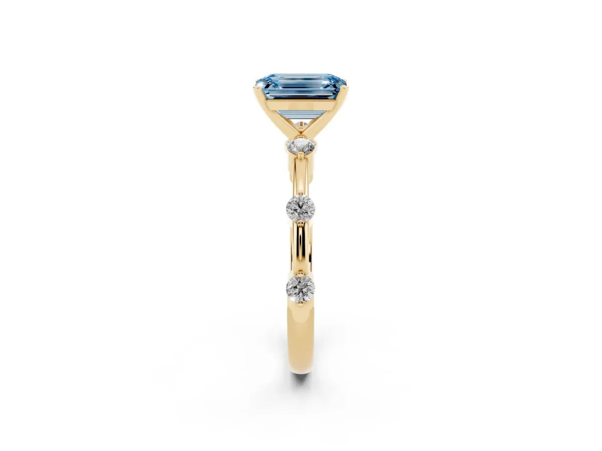 Fancy Blue Emerald Cut Solitaire Diamond Ring with Bezel Set Side Stones and Prong Setting Yellow gold