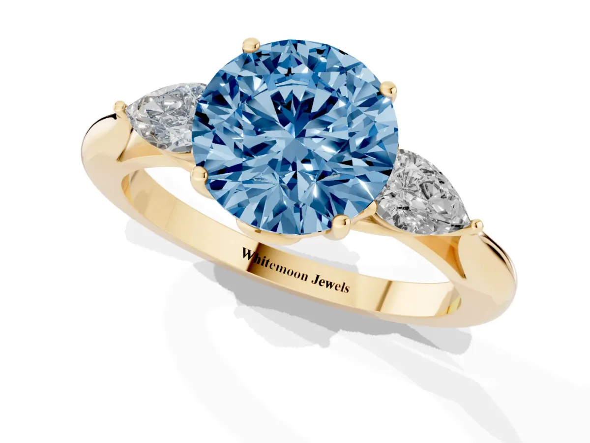 Fancy Blue Three-Stone Round Cut Diamond Ring with Pear Side Stones in Four-Prong Setting Yellow gold