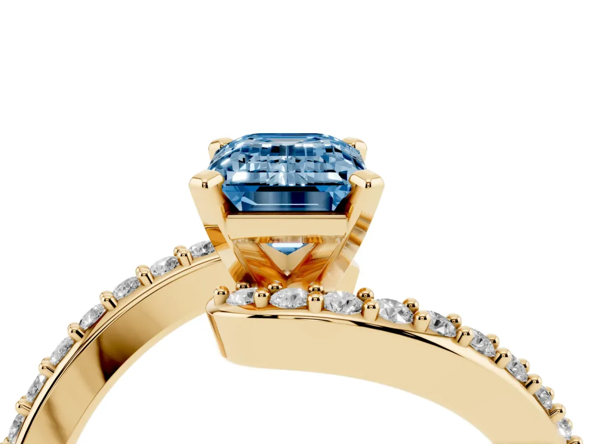 Fancy Blue Emerald Cut Solitaire Twist Band with Pave Set Diamonds and Four-Prong Setting Yellow gold